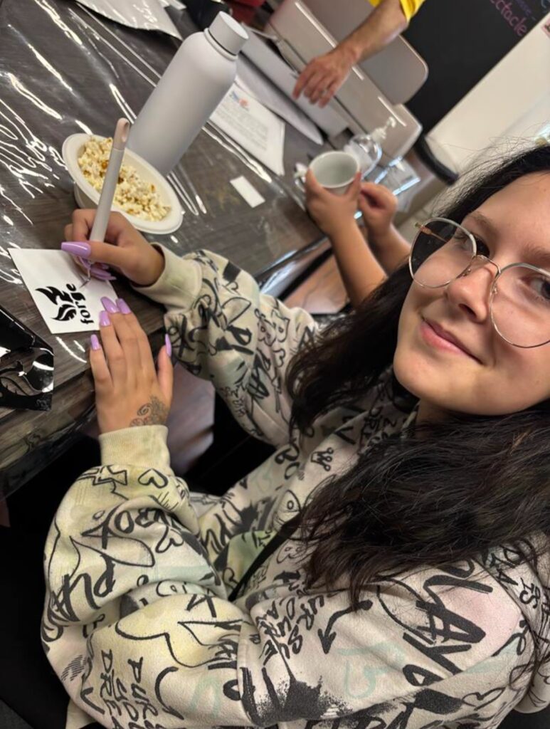 Photo of young person working on creating Forge branded items.